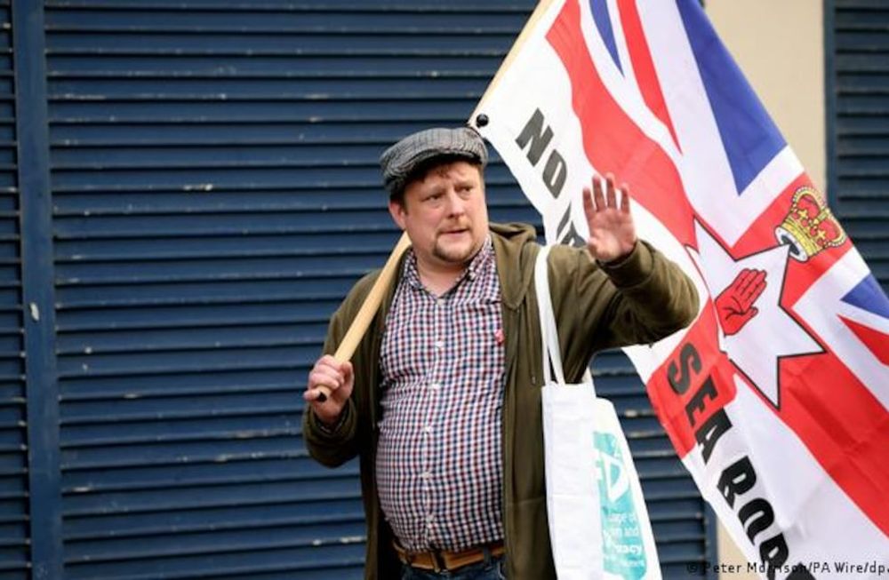 Irlanda del Norte. Un ciudadano protesta con la bandera de Reino Unido y la de Irlanda del Norte por los corredores marítimos comerciales. Imagen de archivo de junio de 2022.