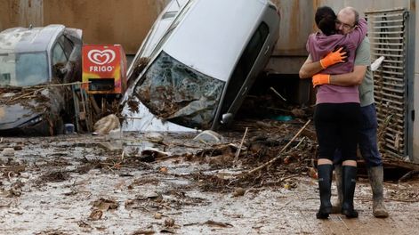Los Andes | Dos vecinos se abrazan a la entrada de un garaje en Paiporta, Valencia, tras el paso de la DANA. EFE/Biel Aliño