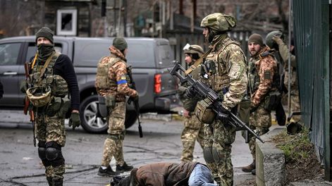 Los Andes | Soldados ucranianos revisan cuerpos de civiles en busca de trampas explosivas en el suburbio de Bucha, Ucrania, anteriormente ocupado por Rusia. (AP)