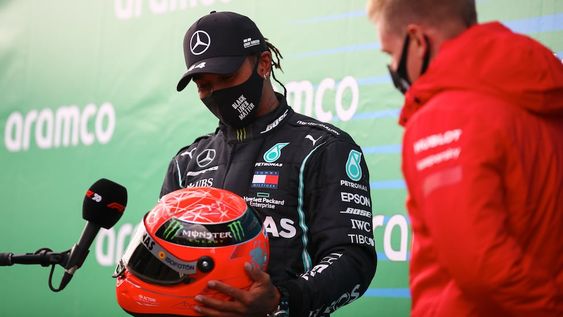 El piloto de Mercedes Lewis Hamilton recibe el casco de Michael Schumacher de parte de su hijo, Mick, luego de ganar el Gran Premio de Nürburgring en Alemania.