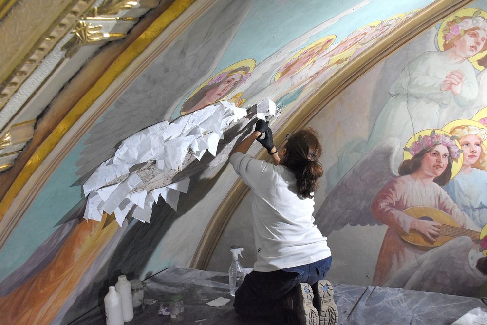 La especialista en restauración de pinturas antiguas, Cristina Sonego, en el retablo del altar, haciendo dorado a la hoja.