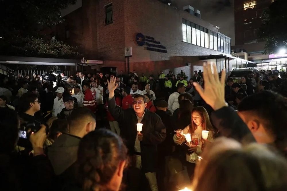 Personas encienden velas a las afueras de la Fundación Santa Fe donde fue trasladado el senador colombiano Miguel Uribe Turbay este sábado, en Bogotá (Colombia).