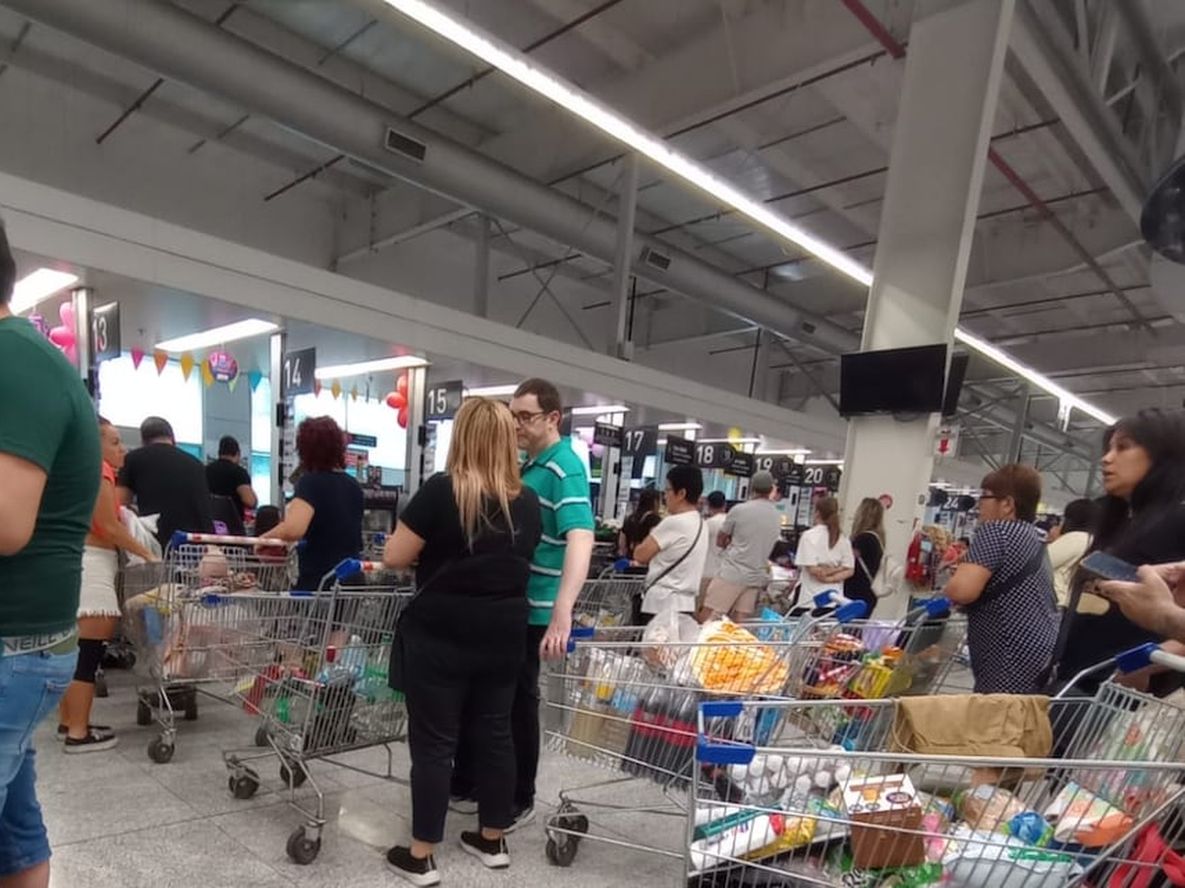 La gente comprando en los supermerados atestados.