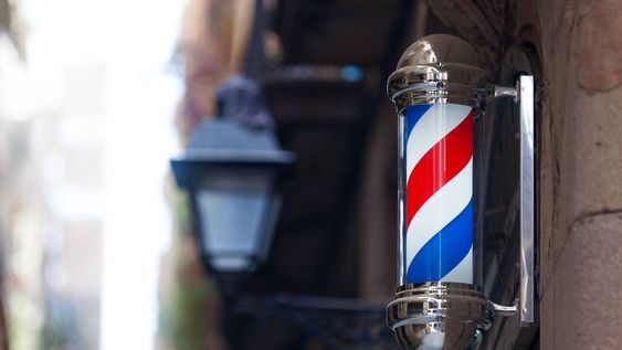 que significa el poste giratorio de colores que aparece en las barberias
