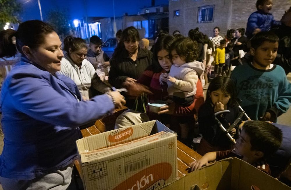 Noche fría en El Algarrobal, Las Heras: Conurbano mendocino.  El país vive una de sus peores crisis económicas contemporáneas y se refleja directamente en el aumento de la gente que concurre a los comedores comunitarios para completar algunas de las cuatro comidas diarias. Allí es donde los números de la pobreza e indigencia adquieren un rostro.  El comedor y merendero Los Horneritos da raciones de comida todos los martes y jueves a más de 1500 personas entre niños, adultos y ancianos.Gabriela Carmona entregando raciones en la puerta del comedor comunitario.Foto: Ignacio Blanco / Los Andes