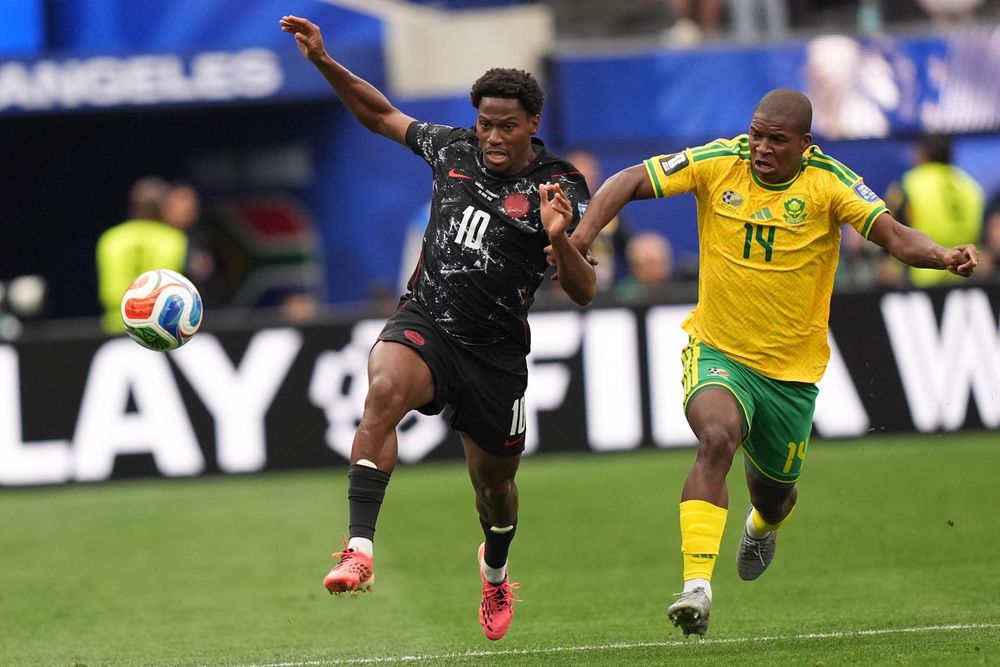 Jonathan David, de Canadá, disputa la pelota con Mbekezeli Mbokazi, de Sudáfrica, durante el partido por los 16avos de final del Mundial 2026, en el SoFi Stadium de Los Ángeles. 