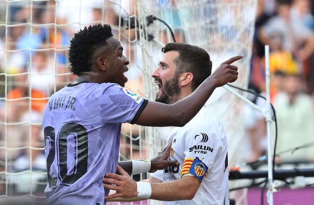 ARCHIVO - Vinicius Junior, izquierda, del Real Madrid, discute con los aficionados del Valencia luego de que éstos lo insultaran por su color de piel durante un partido entre ambos equipos el domingo 21 de mayo de 2023, en Valencia, España. José Luis Gaya del Valencia intenta contener al futbolista brasileño.
