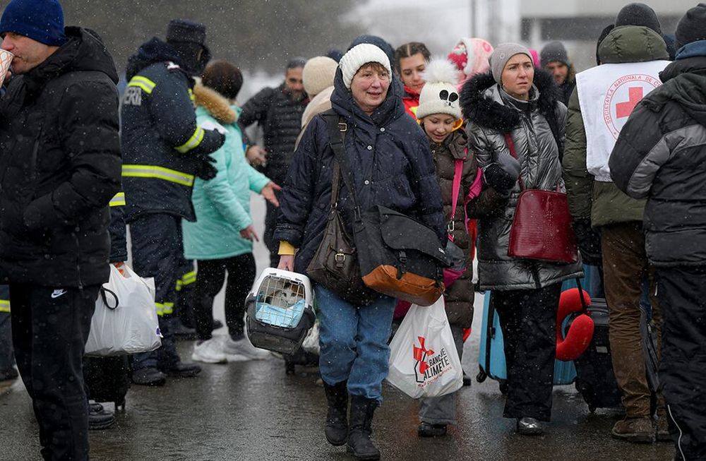 Una refugiada que huye del conflicto desde la vecina Ucrania carga a su gato después de cruzar la frontera rumano-ucraniana, en Siret, Rumania. (AP)