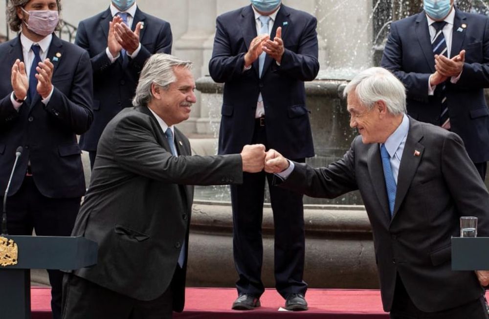 Alberto Fernández golpea con el puño al presidente de Chile, Sebastián Piñera, mientras hacen una declaración conjunta en el palacio presidencial de La Moneda en Santiago. (AP)