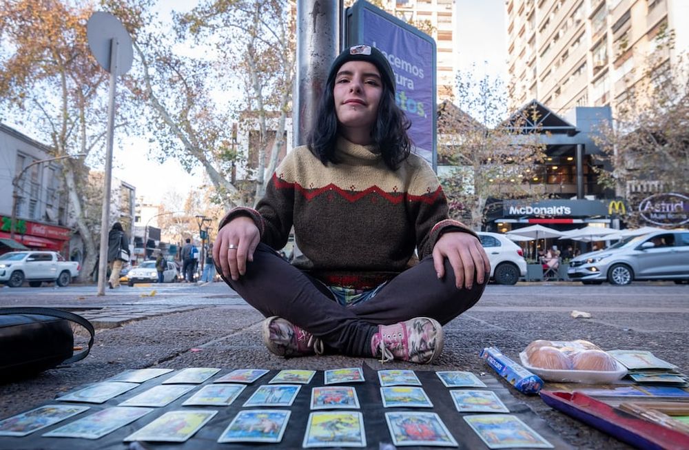 Instalada en un rincón de la vereda Oeste y sólo con un mantel y sus cartas, Vicky llama la atención de quienes pasan por la transitada esquina de San Martín y Espejo. | Foto: Ignacio Blanco / Los Andes
