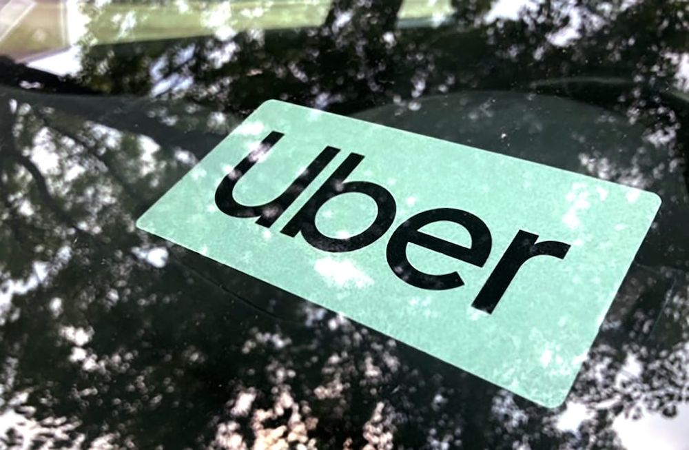 ARCHIVO - Cartel de Uber en un auto en Palatine, Illinois, EEUU, 22 de mayo de 2023. Uber elevó la edad mínima requerida a sus conductores nuevos en California a 25 años el jueves 24 de agosto de 2023, bajo normas que la empresa considera necesarias dado el aumento de los costos del seguro automotor en ese estado. (AP Foto/Nam Y. Huh,File)