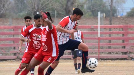 Los Andes | El Flaco Jesús Baldaccini se lleva el balón ante la marca de dos jugadores de Algarrobal. Talleres goleó y manda en la zona A. / Gentileza Andrés Arequipa.
