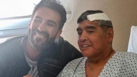Diego Maradona junto a su médico personal, Leopoldo Luque antes de abandonar la clínica luego de una operación. / Gentileza.