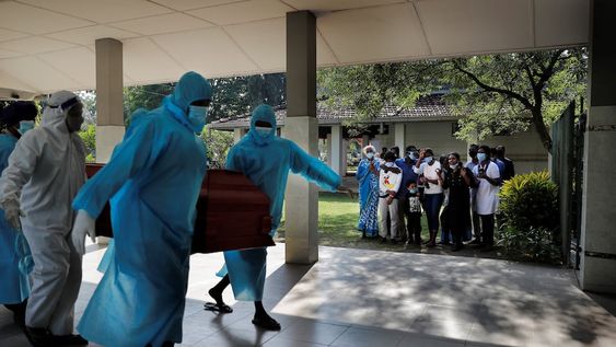 Una familia cristiana de Sri Lanka se lamenta cuando los trabajadores del cementerio municipal llevan el cuerpo de su familiar que murió de COVID-19 para la cremación en Colombo.