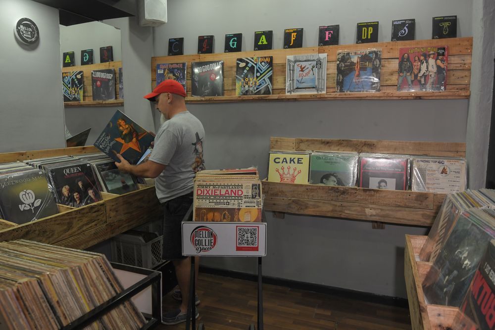 Furor por los vinilos, crece la cantidad de gente que compra y colecciona discos. Gastón Arro de Mellon Collie discos ordena los vinilos en su local. Foto: Marcelo Rolland / Los Andes