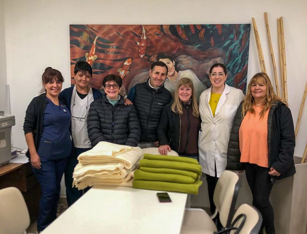 Nélida (jaqueta preta e calça branca) recebendo doação de mantas de lã da diretora do Hospital Tagarelli, Dra. Silvina Córdoba Sudatti.