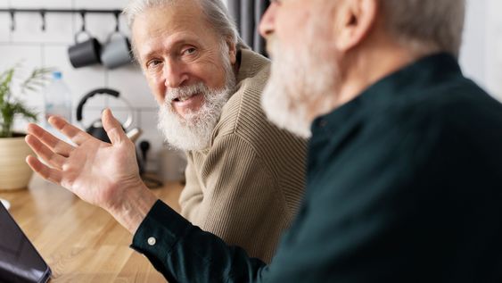 Dos adultos conversan en un café. Foto: Freepik.
