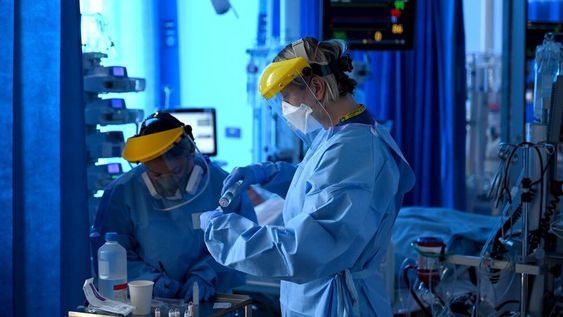 Miembros del personal clínico usan equipos de protección personal (EPP) mientras trabajan en la unidad de Cuidados Intensivos del Hospital