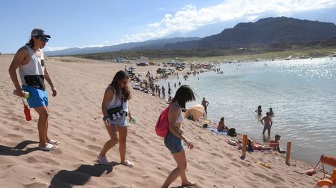 Los Andes | El bajo nivel del dique obliga a los visitantes a caminar desde la ruta para llegar al agua. Algunos se aventuran en sus camionetas hasta la orilla. Foto: Jose Gutierrez