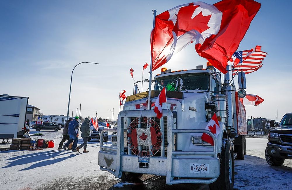 The last truck blocking the southbound lane moves after a breakthrough resolved the impasse where anti-COVID-19 vaccine mandate demonstrators blocked the highway at the busy U.S. border crossing in Coutts, Alberta, Wednesday, Feb. 2, 2022. (Jeff McIntosh /The Canadian Press via AP)