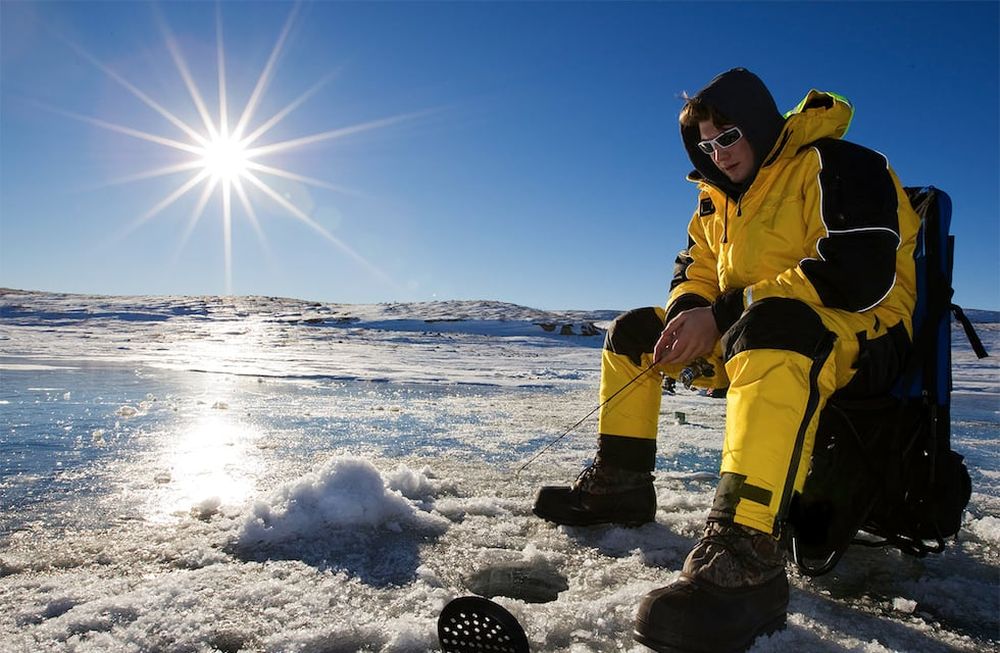Los orificios sobre el hielo permiten a los pescadores arrojar sus líneas en el río Santa Ana. La mayoría espera en decenas de cabañas con un rústico confort interior.