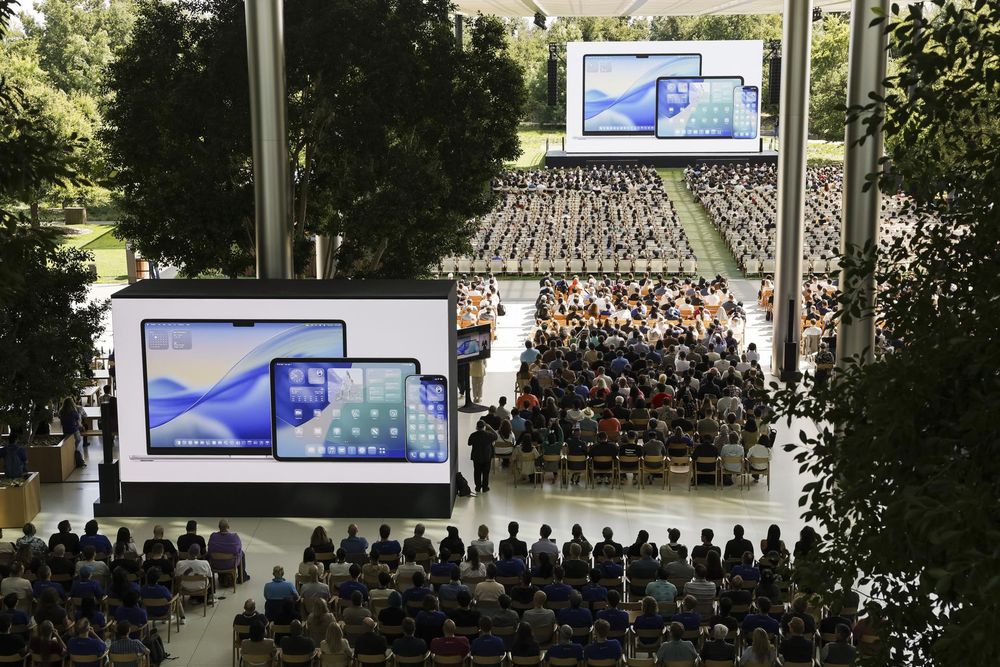 Während der Apple Worldwide Developers Conference (WWDC) 2025 am 9. Juni auf dem Apple Park Campus in Cupertino, Kalifornien, USA, sehen sich Leute ein Video über neue Software- und Geräteentwicklungen von Apple an.