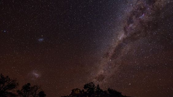 Las Nubes de Magallanes (izquierda de la foto) pueden apreciarse en el cielo nocturno del Hemisferio Sur. Estas dos galaxias están acercándose en su primer viaje hacia la Vía Láctea (derecha de la foto).