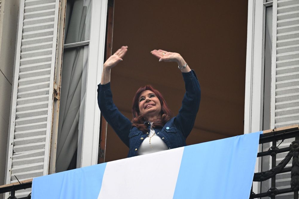 La ex presidenta Cristina Kirchner saluda a los militantes que marcharon hasta su domicilio en el barrio porte&ntilde;o de Constituci&oacute;n en el D&iacute;a de la Lealtad.