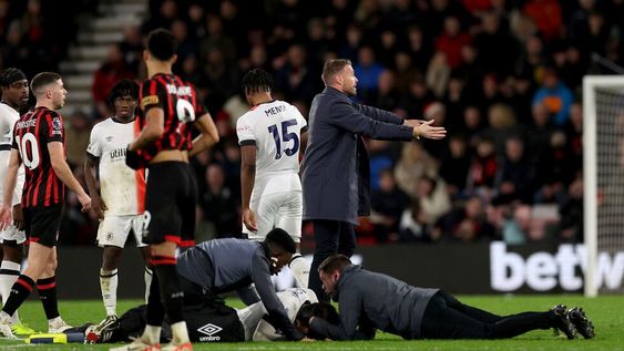 El técnico del Luton hace un gesto en la cancha mientras Tom Lockyer es auxiliado por el cuerpo médico en la cancha durante el encuentro de la Liga Premier ante el Bournemouth el sábado 16 de diciembre del 2023. (Steven Paston/PA via AP)