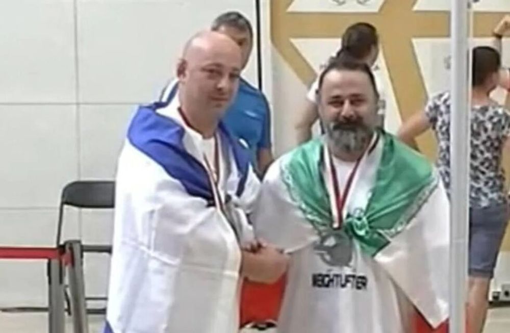 Maksim Svirsky y Mustafa Rajaei, atletas israelí e iraní respectivamente, dándose la mano luego de quedar tercero y segundo en una competencia de levantamiento de pesas en Polonia.