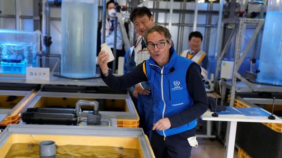 Rafael Mariano Grossi, director del Organismo Internacional de Energía Atómica (OIEA), muestra una botella vacía después de que alimentó platija en un tanque lleno de aguas residuales tratadas en un laboratorio, durante su visita a la dañada central nuclear de Fukushima el 05.07.2023.