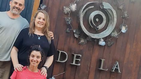 Frente al portón de la bodega:&nbsp;Elías y Adriana Gómez junto a Karen Aidar, artesana sancarlina que diseñó y creó toda la ornamentación metálica del portón.&nbsp;