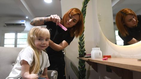 Los Andes | Campaña de corte solidario para juntar dinero para ayudar a Juanita, la nena que tienen que realizarle una operación en sus manos.Sol le hace las trensas a Juanita Foto: José Gutierrez / Los Andes