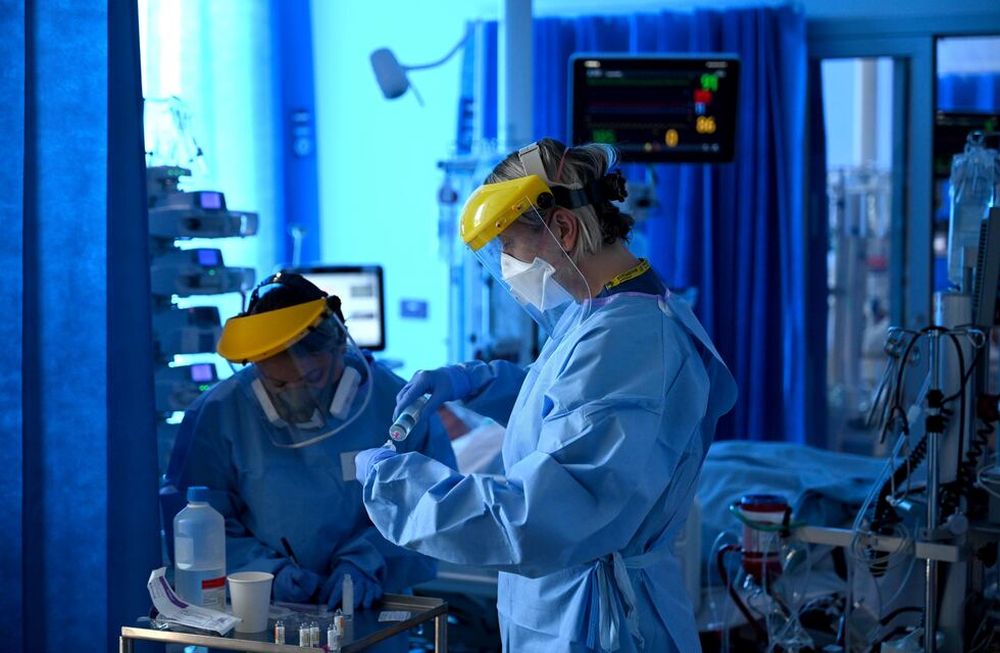 Miembros del personal clínico usan equipos de protección personal (EPP) mientras trabajan en la unidad de Cuidados Intensivos del Hospital