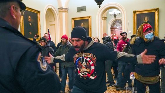 Simpatizantes del presidente Donald Trump se enfrentan a la policía del Capitolio en el pasillo afuera del recinto del Senado, el miércoles 6 de enero de 2021, en Washington. AP Foto / Manuel Balce Ceneta