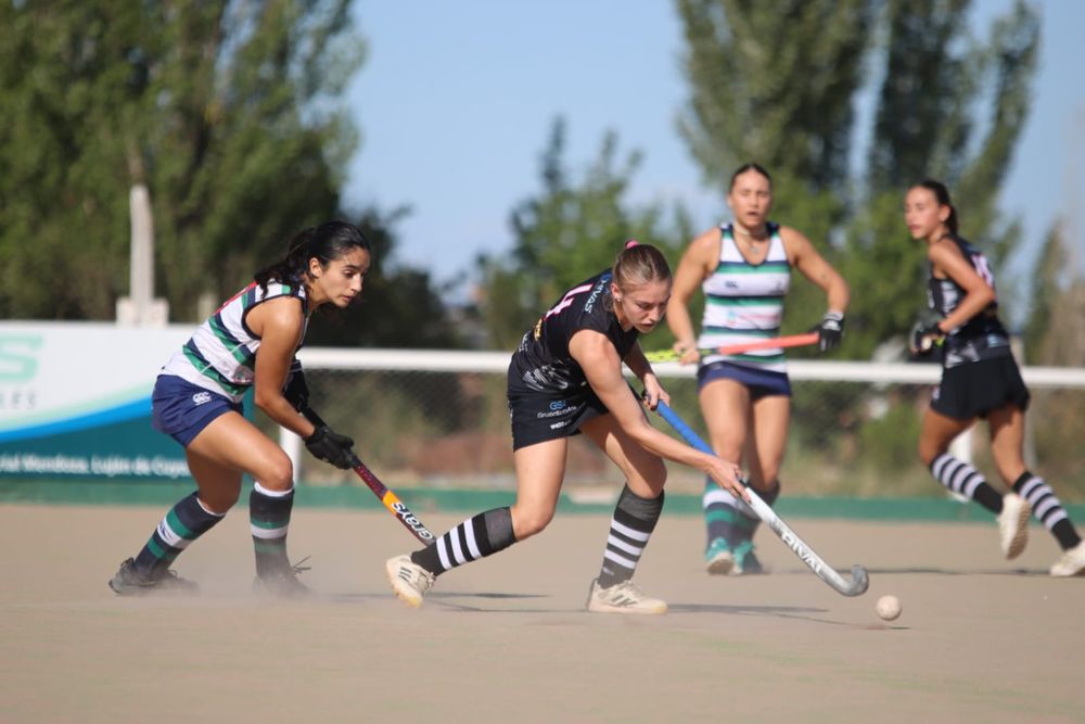 Hockey Césped. Catalina Castro quiere la bocha que tiene Emilia Noseda. Al fondo mira Marina Caballero autora del primer gol. La escena pertenece al juego protagonizado entre Peumayén y San Juan Rugby