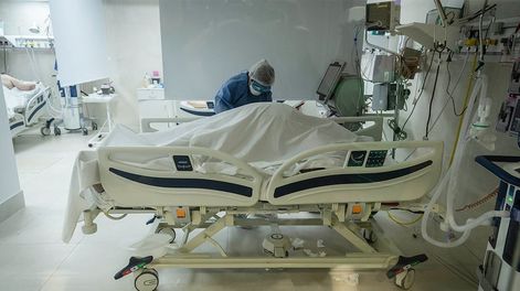 Los Andes | En la sala de terapia intensiva del Hospital El Carmen, la enfermera Érica Blanco cubre el cuerpo de un paciente que no pudo resistir el embate del virus. / Foto: Ignacio Blanco