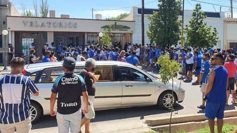 Los Andes | Tristeza. El carruaje espera por los restos del ídolo mientras cientos de hinchas del Tomba aguardan en la calle y las veredas para dedicarle el último aliento al goleador eterno. / Gentileza: Cuyonoticias