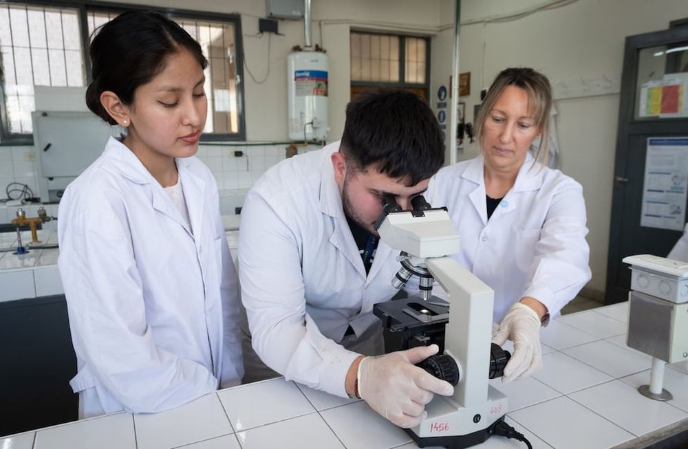 Catriel Montivero y Milagro Irazabal son supervisados por la maestra de enseñanza práctica de laboratorio Jorgelina Antunez en la escuela Bernardo Houssay. | Foto: Ignacio Blanco / Los Andes