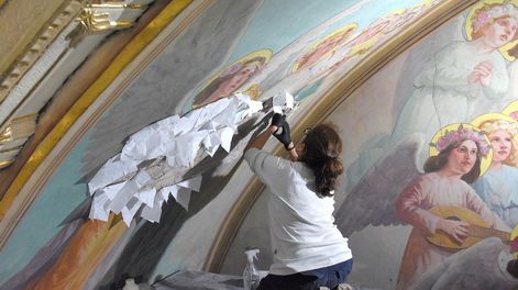 La especialista en restauración de pinturas antiguas, Cristina Sonego, en el retablo del altar, haciendo dorado a la hoja.