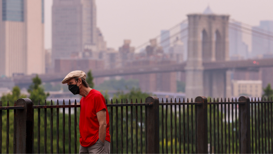 Una persona lleva una mascarilla mientras se observa humo de incendios forestales entre el horizonte de Manhattan y el Puente de Brooklyn desde el Paseo Marítimo de Brooklyn, en el distrito de Brooklyn de Nueva York, Nueva York, EE. UU., 16 de julio de 2026. El Servicio Meteorológico Nacional ha emitido una alerta de calidad del aire hasta el final del día del 16 de julio en Nueva York debido al humo de incendios forestales en Canadá que afecta la calidad del aire en varios estados de EE. UU.