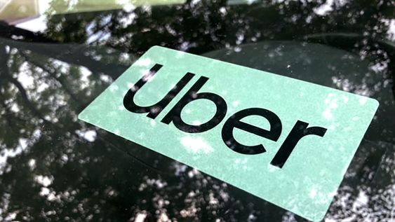 ARCHIVO - Cartel de Uber en un auto en Palatine, Illinois, EEUU, 22 de mayo de 2023. Uber elevó la edad mínima requerida a sus conductores nuevos en California a 25 años el jueves 24 de agosto de 2023, bajo normas que la empresa considera necesarias dado el aumento de los costos del seguro automotor en ese estado. (AP Foto/Nam Y. Huh,File)