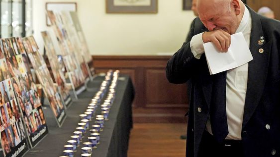 Un hombre observa carteles con imágenes de víctimas mientras asiste a una ceremonia oficial de conmemoración en la Gran Sinagoga de Bruselas. (AP)
