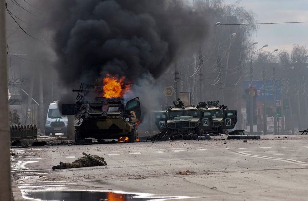 Un vehículo blindado de transporte de personal ruso arde en medio de vehículos utilitarios ligeros dañados y abandonados después de los combates en Kharkiv. (AP)