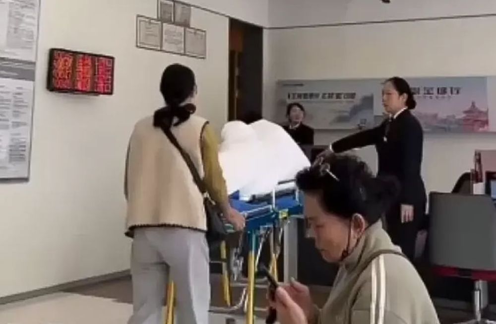 La mujer tuvo que llevar a su abuelo en camilla hasta el banco / Captura de vido