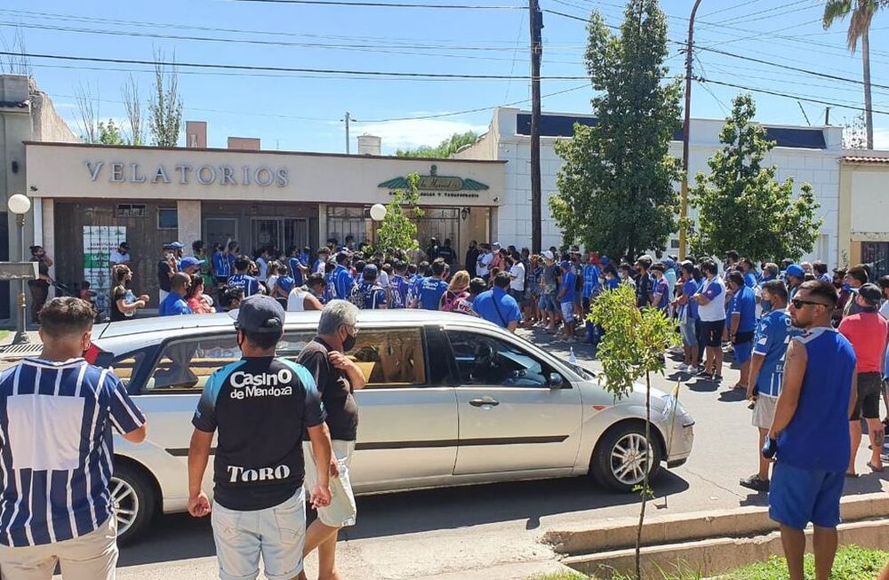 Tristeza. El carruaje espera por los restos del ídolo mientras cientos de hinchas del Tomba aguardan en la calle y las veredas para dedicarle el último aliento al goleador eterno. / Gentileza: Cuyonoticias