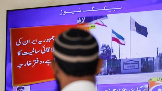 Un hombre mirando las noticias a Pakistán, donde informan del ataque que el país ha lanzado a Irán en represalia por los misiles que recibieron en su territorio del día anterior.