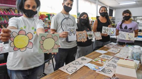 La artista Luisa Olguín junto a quienes la ayudan a montar el futuro mural en Luján, con dibujos de los chicos / Mariana Villa
