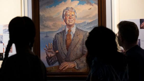 Visitantes pasan frente a un retrato del presidente Jimmy Carter durante una celebración por su cumpleaños 99 en el Centro Carter, el sábado 30 de septiembre de 2023, en Atlanta. (AP Foto/Ben Gray)