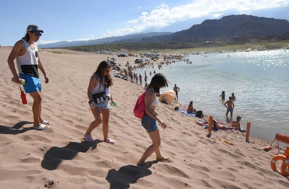 El bajo nivel del dique obliga a los visitantes a caminar desde la ruta para llegar al agua. Algunos se aventuran en sus camionetas hasta la orilla. Foto: Jose Gutierrez